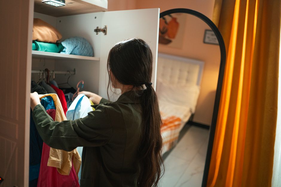 Woman happily organizing clothes in her newly installed custom wardrobe