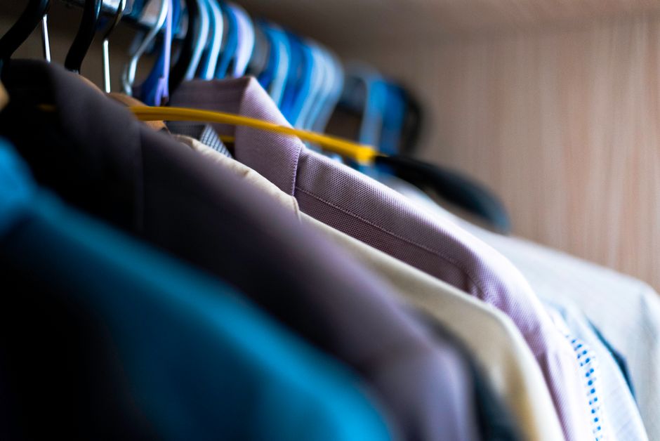 Neatly organized clothes hanging in a modern closet